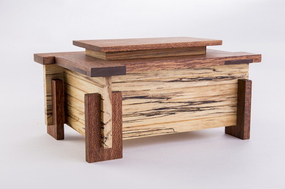Frank Lloyd Wright-inspired box by Myron Wilson. Photo by Dero Sanford. Wooden box with geometric design, layered wood pattern, and vertical corner supports.