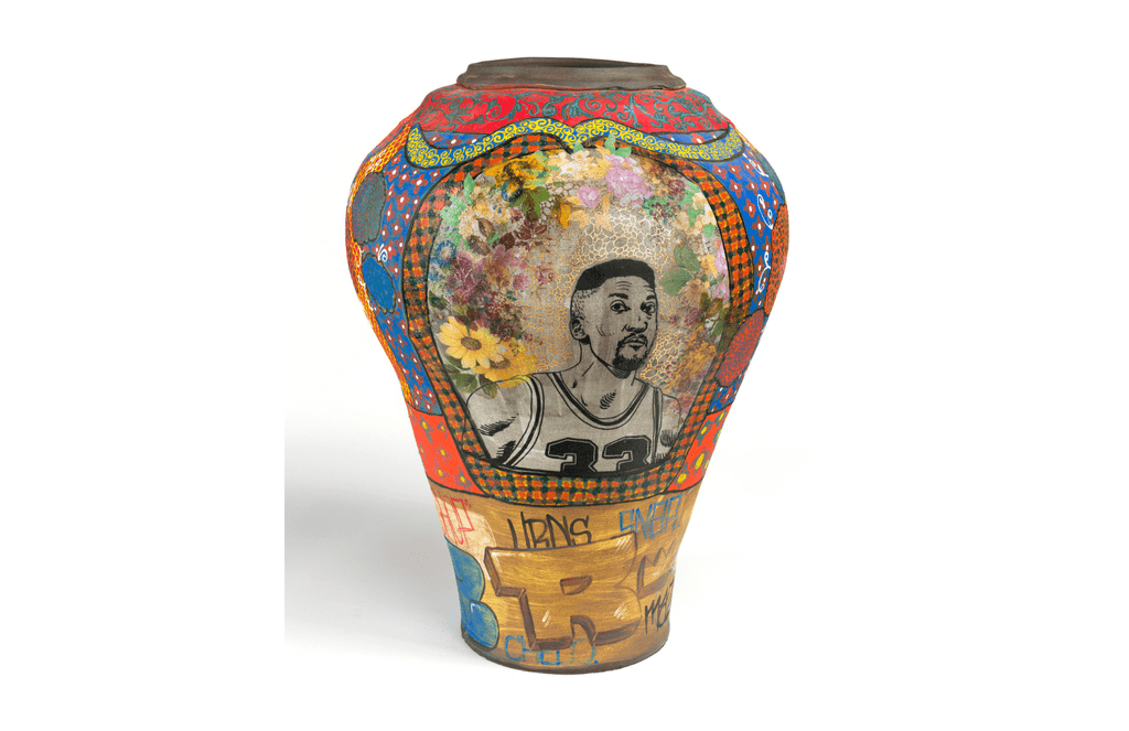 Colorido jarrón con elaborados patrones, diseños florales, retrato deportivo y letras de graffiti.